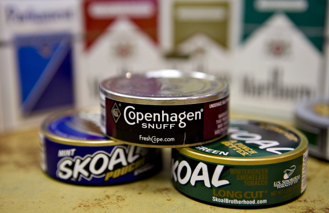 Cans of Skoal and Copenhagen brand smokeless tobacco sit on display in front of Marlboro and Parliament brand cigarettes in a deli in New York, U.S., on Thursday, Jan. 28, 2010. Altria Group Inc., the largest U.S. tobacco company, said fourth-quarter profit rose 6.8 percent, bolstered by the acquisition of snuff maker UST Inc. Photographer: Daniel Acker/Bloomberg via Getty Images